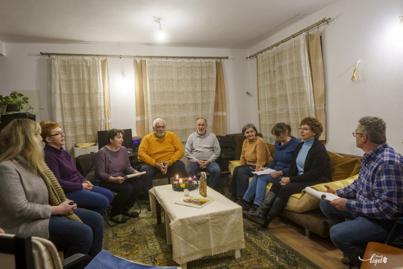 A fehér asztalra tett megszentelt szobor körül gyűlnek össze az imádkozók •  Fotó: Haáz Vince